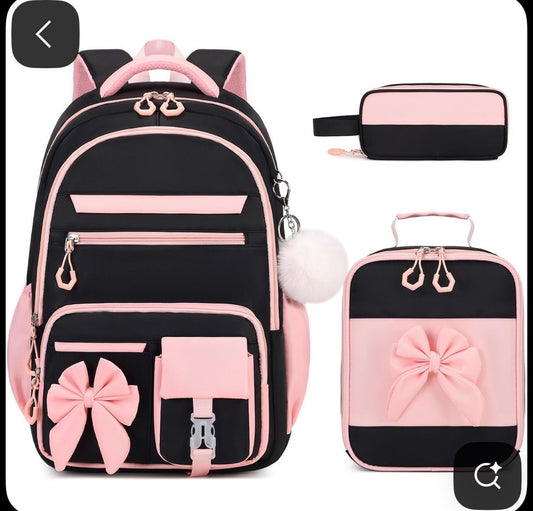 • Large Backpack: The main bag features multiple zippered compartments, side pockets (likely for water bottles), and ergonomic padded shoulder straps.
• Insulated Lunch Bag: Matches the backpack's design with a large decorative bow and a top carry handle.